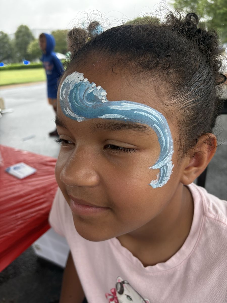 Blue and white breaking ocean wave design painted across the forehead and temple