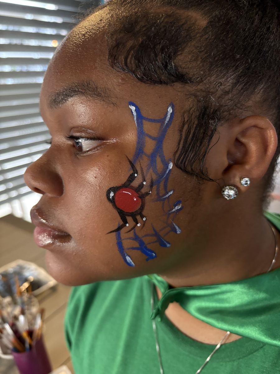 Red and black spider on a blue web cheek design with white highlights